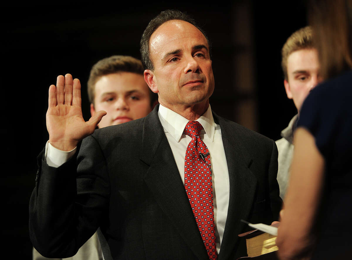 Backed by his sons Robert, left, and Joseph, and with his hand on a Bible held by his mother Josephine, Joe Ganim is sworn in as Bridgeport mayor in a ceremony at the Klein Memorial Auditorium in Bridgeport on Tuesday.