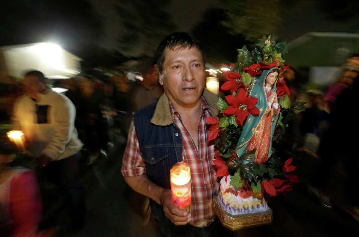 Justino Hernandez carries a Virgin of Guadalupe statue during a procession with Danza los Gorriones last month in Houston.