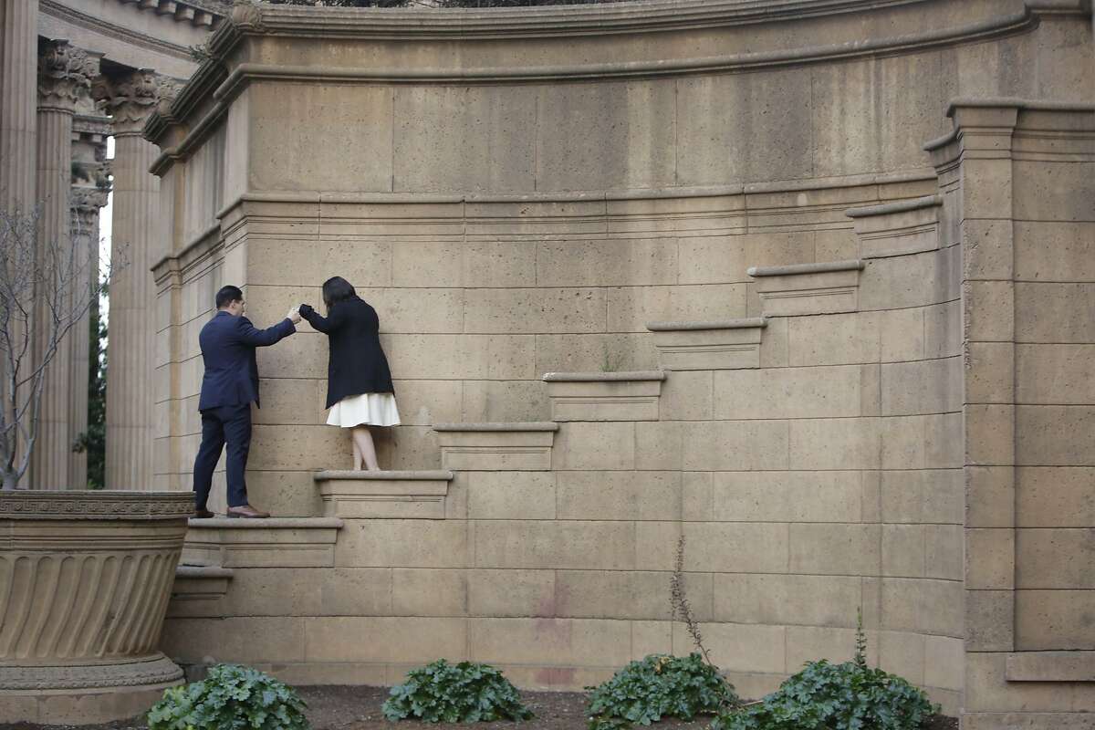 Gabriel Martinez (l to r) of San Jose leads Gabriela De La Torre of San Martin down steps on the rotunda at the Palace of Fine Arts after they posed for engagement photos on Wednesday, December 2, 2015 in San Francisco, Calif.