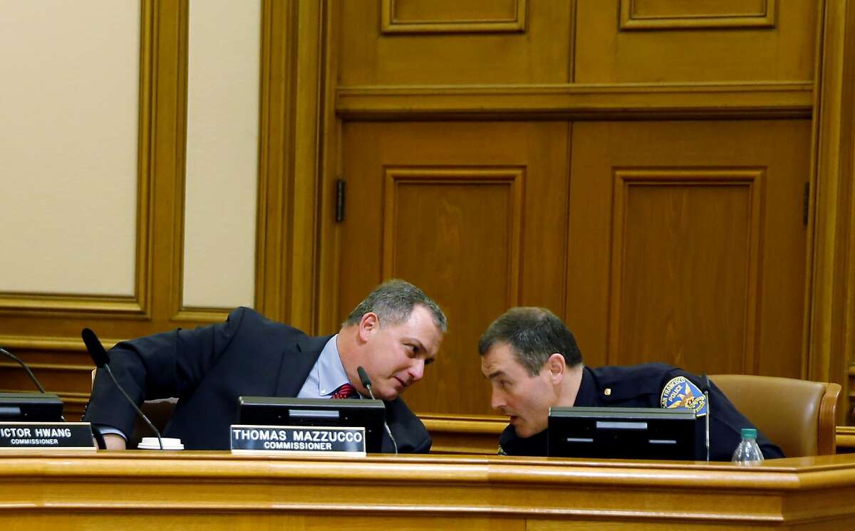Commissioner Thomas Mazzucco (left) leans over to talk with San Francisco Police Department Deputy Chief Hector Sainez during a meeting of the San Francisco Police Commission at City Hall in San Francisco, California, on Wednesday, Dec. 2, 2015.