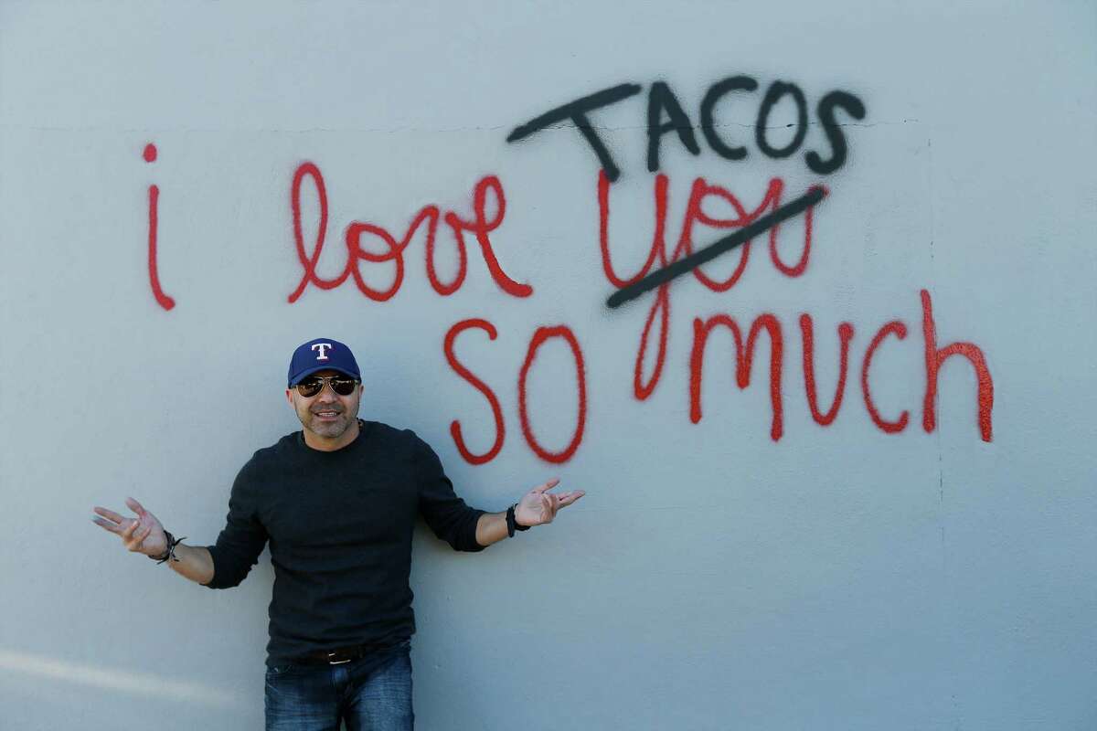 Luis Munoz poses with his re-created work of art, "I love tacos so much," which had gained social media attraction earlier in the week after it was accidentally painted over by the city on Thursday, Dec. 3, 2015. After city employees were informed of their mistake, they supplied Munoz with paint and he went back to the now gray wall to remake his ode to the city and to tacos. Dozens of people who were informed of the incident via social media turned out to show their support as he re-created his art on the wall. Munoz created the artwork partly as an homage to a mural he saw in Austin and partly due to his love for tacos and the city. When social media took notice, Munoz decided to dedicate his artwork to charity whenever someone reposted his work. He was relieved to re-create his work of art but was also saddened that his original was no longer visible. However, his new homage still garnered attention from social media as well as by-passers who stopped for photos.
