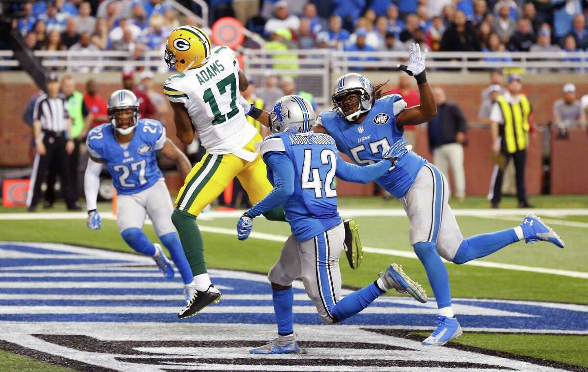 Green Bay Packers wide receiver Davante Adams (17), defended by Detroit Lions free safety Glover Quin (27), strong safety Isa Abdul-Quddus (42) and outside linebacker Josh Bynes (57) scores a touchdown during the second half of an NFL football game, Thursday, Dec. 3, 2015, in Detroit. (AP Photo/Paul Sancya) ORG XMIT: DTF123