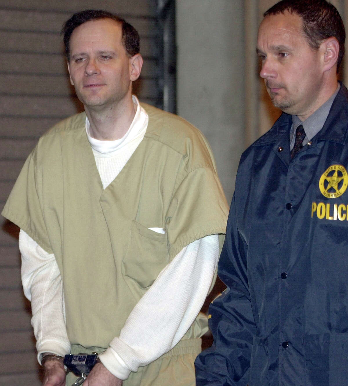 FILE - In this May 15, 2002 file photo, Martin Frankel, a financier accused of stealing more than $200 million from insurance companies, is escorted from U.S. District Court in New Haven, Conn. Frankel was sentenced in 2004 to 17 years behind bars, and released to a halfway house in September 2015. Frankel is due back in New Haven federal court Thursday, Oct. 1, 2015, less than a month after getting out of prison, charged with violating the terms of his release. (AP Photo/Bob Child, File)