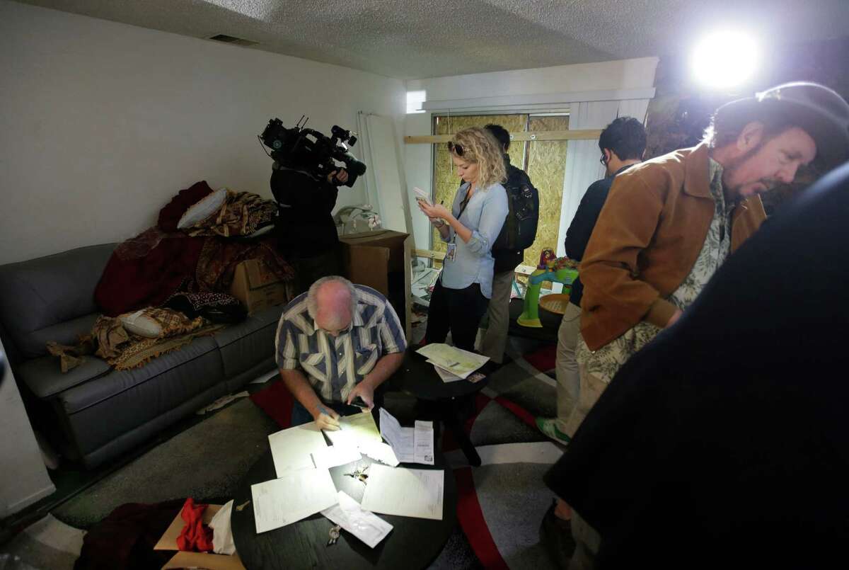 Members of the media crowd into the living room of an apartment in Redlands, Calif., shared by San Bernardino shooting rampage suspects Syed Farook and his wife, Tashfeen Malik, Friday, Dec. 4, 2015, after the building landlord invited media into the townhouse rented by the California attackers.
