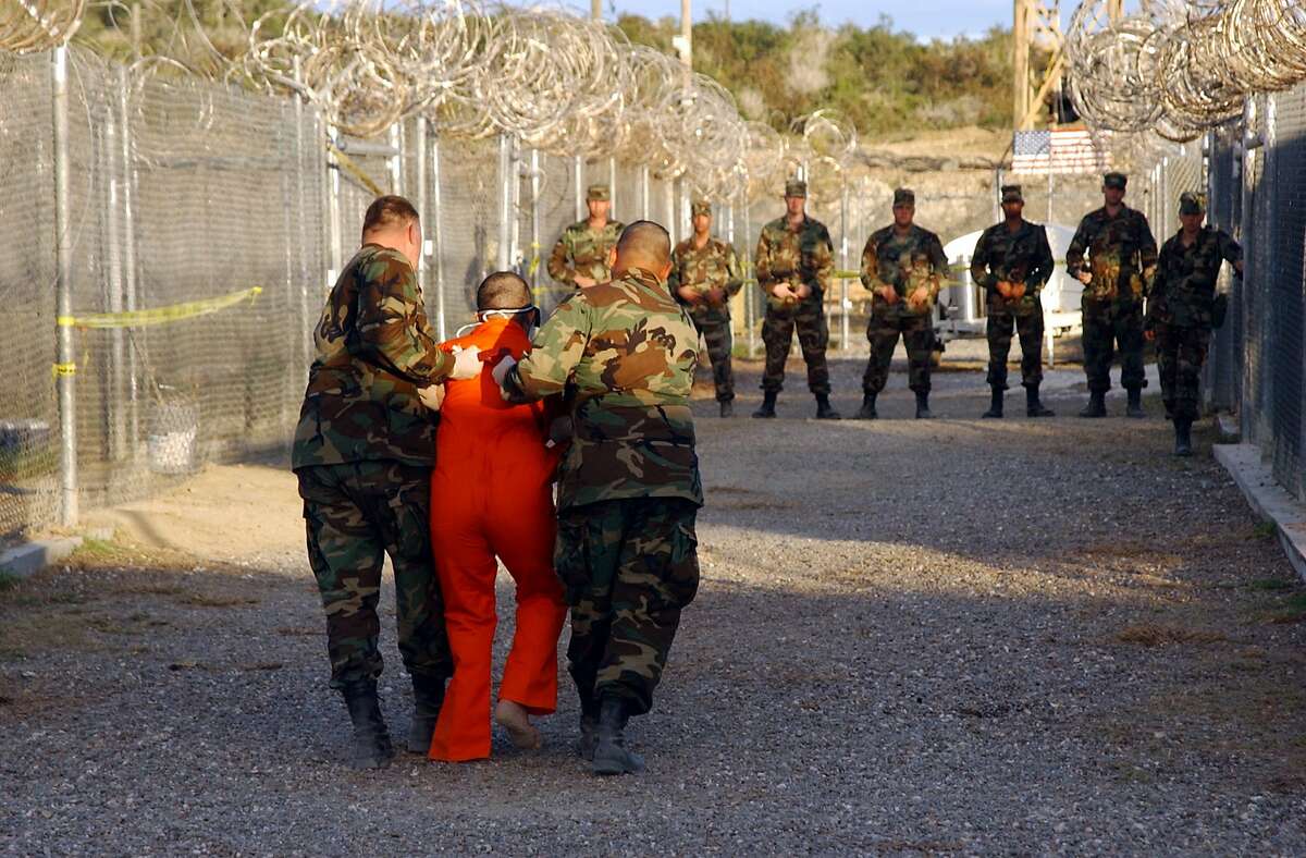 Taliban and al-Qaida detainees in orange jumpsuits sit in a holding area during in-processing to the temporary detention facility on Jan. 18, 2002, in Guantanamo Bay, Cuba. The Senate Select Committee on Intelligence released a report on the CIA's interrogation practices. The report said the CIA misled Americans and government policymakers about the effectiveness of the program that was secretly put into place after the 9/11 terror attacks. (Shane T. McCoy/ZUMA/TNS)