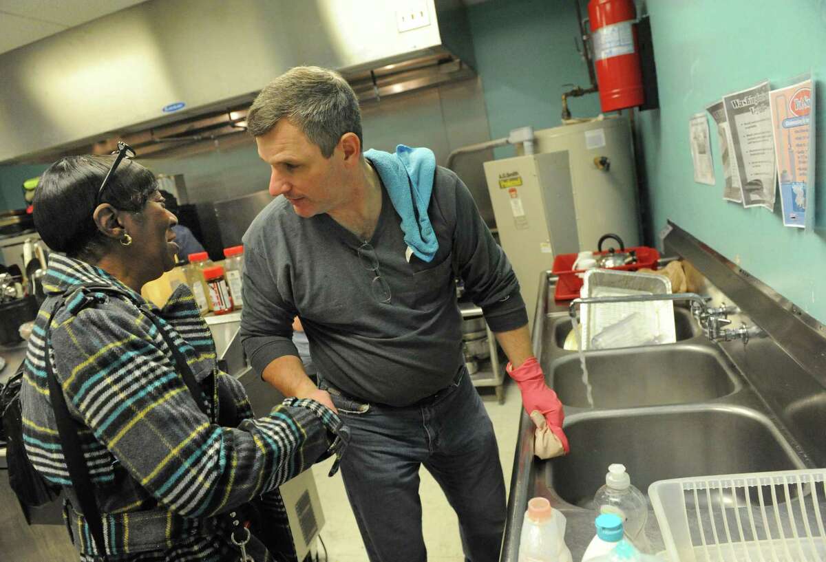 Albany Police Chief Brendan Cox takes a break from washing dishes to talk with fire victim Helen Holmes during a Dominican and soul food dinner to benefit the victims of the South End fires and their families at Reigning Life Family Church on Saturday Dec. 5, 2015 in Albany, N.Y. The event was organized by AVillage...Inc., the church and the Alcantara family and friends. (Michael P. Farrell/Times Union)