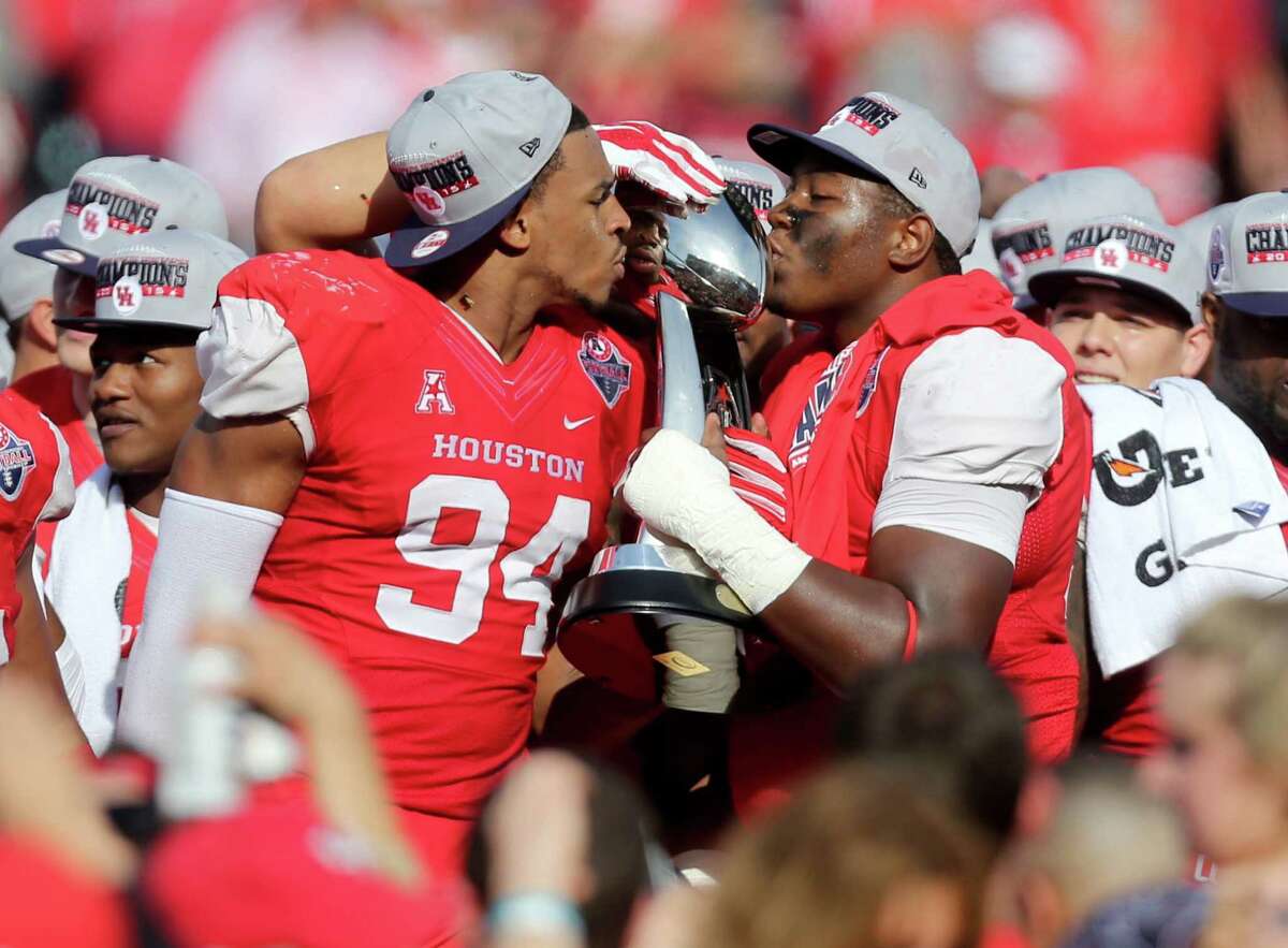 Houston Cougars defensive end Cameron Malveaux (94) and Houston Cougars defensive lineman Nick Thurman (91) kiss the American Athletic Conference Champion trophy after the Cougars defeated the Temple Owls 24-13 in the inaugural game played at TDECU Stadium Saturday, Dec. 5, 2015, in Houston, Texas.