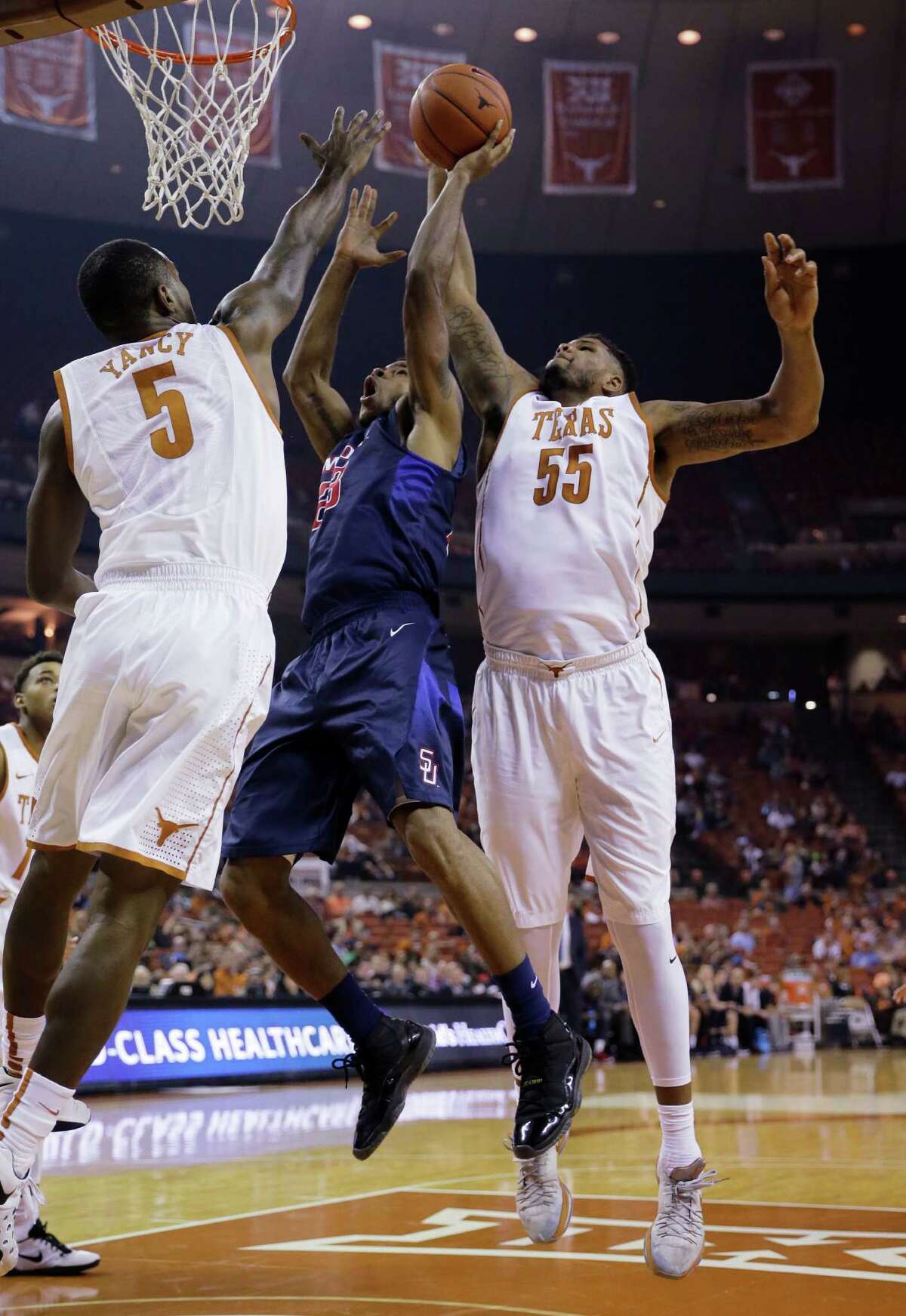 2720 x 3950~~$~~Samford forward Iman Johnson (23) is stopped by Texas defenders Kendal Yancy (5) and Cameron Ridley (55) during the first half of an NCAA college basketball game Friday, Dec. 4, 2015, in Austin, Texas.