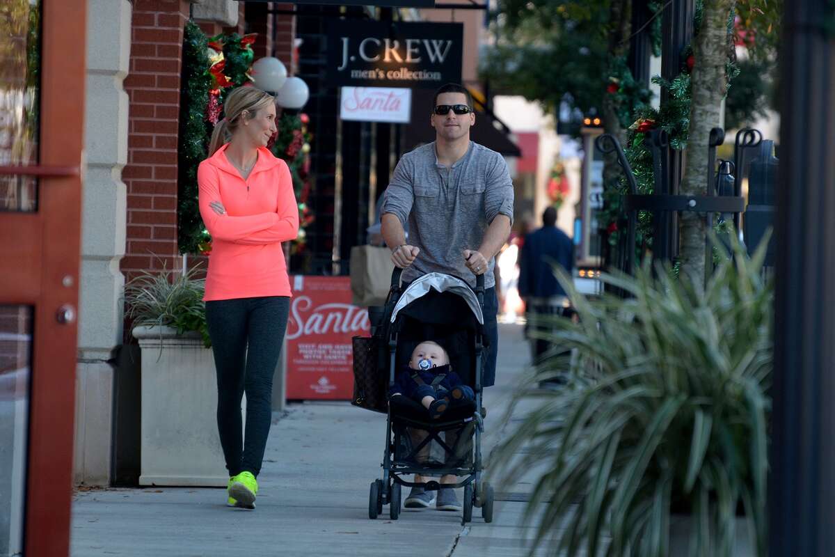 Kimberly Bonilla, from left, and her husband Will, of Spring, stroll with their son Brady, 10 months, in Market Street in The Woodlands on Dec. 4, 2015. (Photo by Jerry Baker/Freelance)