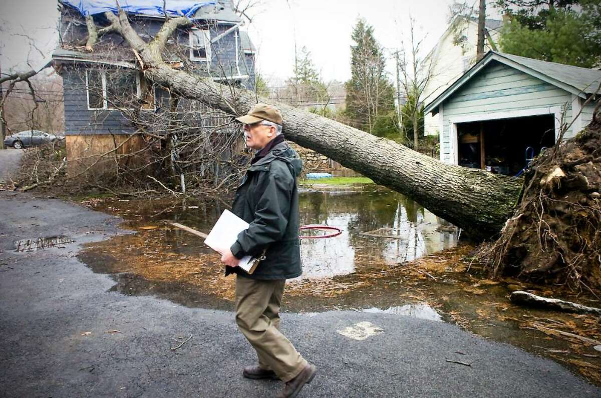 Louis Narciso, FEMA Disaster Assistance Employee, assesses the damage to a house on High Ridge Road as officials from the state, Red Cross and FEMA tour the city after the storm earlier this month in Stamford, Conn. on Wednesday March, 31, 2010