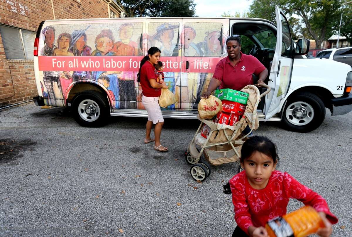 Driver Karen Hicks helps Aura Velasco to put her purchases in a "Magic Bus" in Houston.