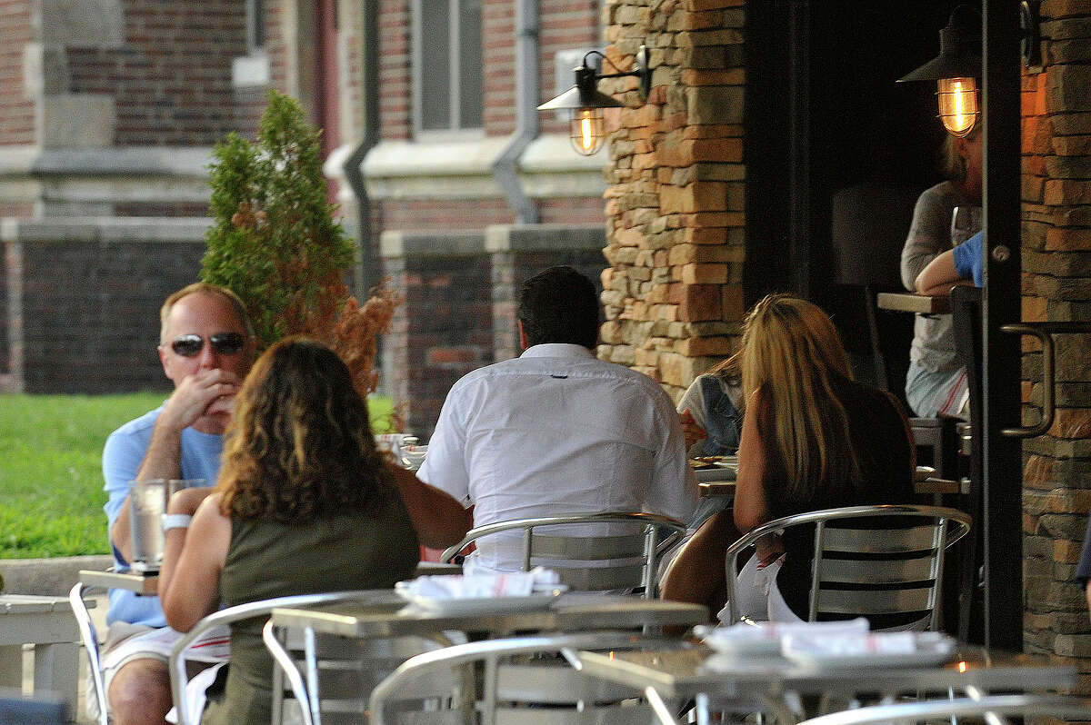 Patrons sit outside Bar Rosso in downtown Stamford in August. Restaurants that offer outdoor dining will now have to pay an annual $250 fee to the city, whether the dining area is on private or public property. Establishments with tables on public property have to pay $2 a square foot on top of the fee.