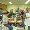 Ellie von Wellsheim, in apron at right, and other volunteers prepare meals in 2014 for the annual Dining for Dollars fundraiser. The effort this year is making cookies and quick breads instead of lasagna. (Provided photo.)