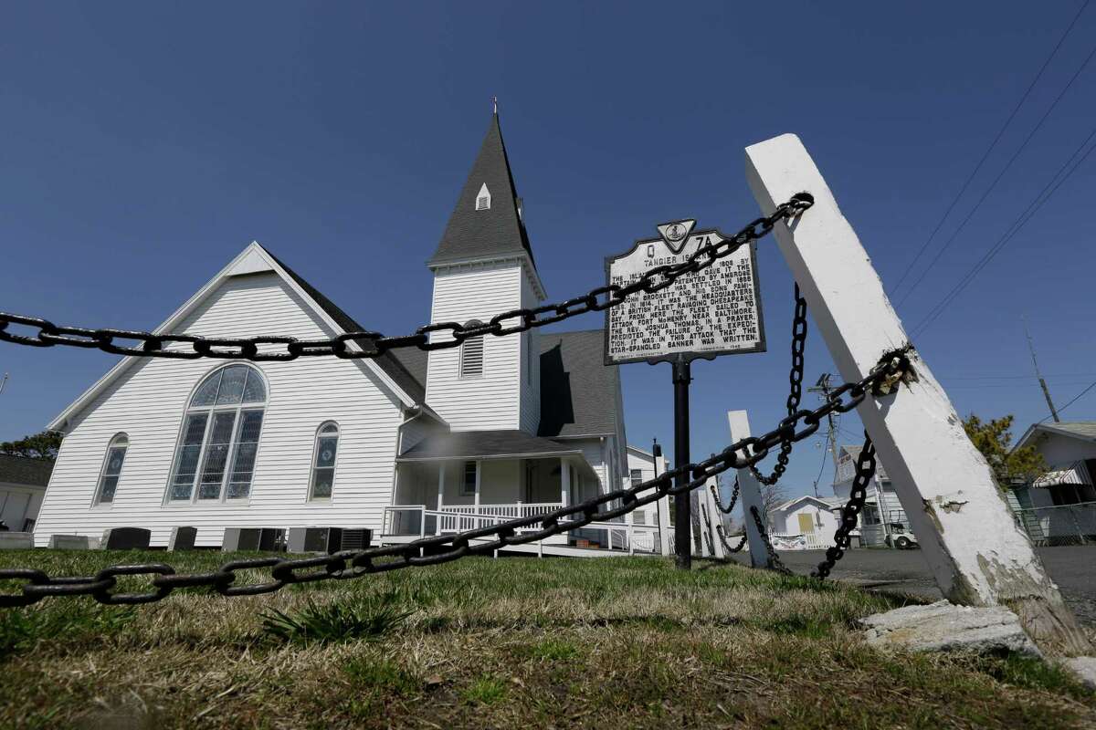 FILE - This Wednesday April 3, 2013 file photo shows a chain fence that surrounds the Swain Memorial Church on Tangier Island, Va. The island and portions of the Virginia coast along Chesapeake Bay are especially vulnerable to climate change because of glaciers thousands of years ago that gouged out the 200-mile bay and a meteor a meteor that slammed into the lower bay 35 million years ago like an exclamation point.