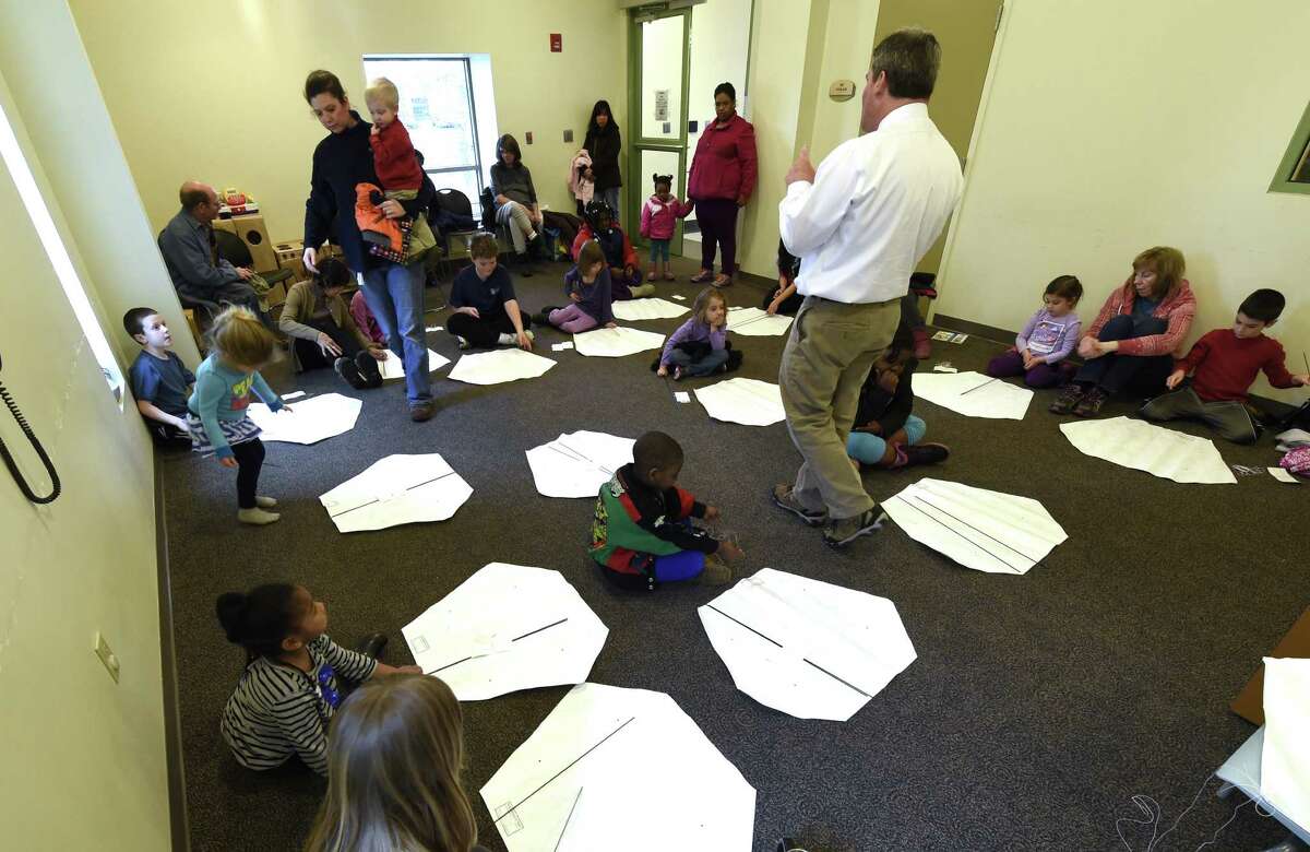 Children's librarian Lee Ricci gathers a large group of prospective kite flyers Wednesday, April 8, 2015, during kite making class at the Bach branch of the Albany Public Library in Albany, N.Y. (Skip Dickstein/Times Union) ORG XMIT: MER2015040815272780
