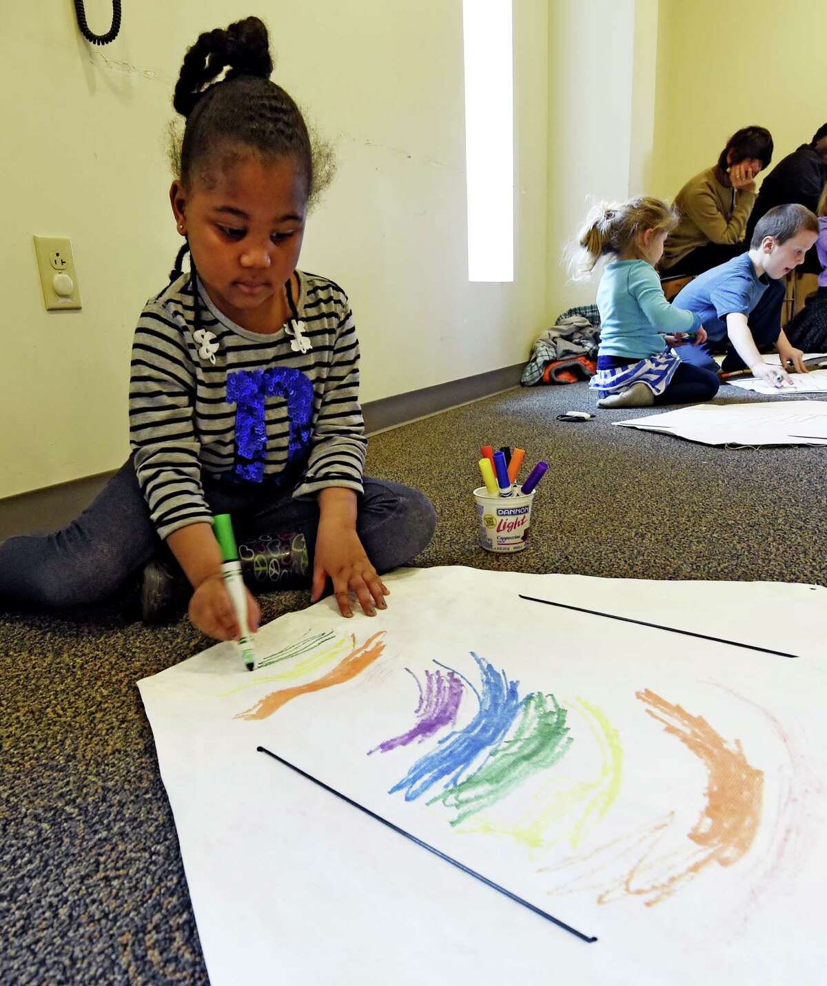 Sabriyya Chandler, 5, puts some personal artwork on her kite Wednesday, April 8, 2015, during kite making class at the Bach branch of the Albany Public Library in Albany, N.Y. (Skip Dickstein/Times Union) ORG XMIT: MER2015040815281486