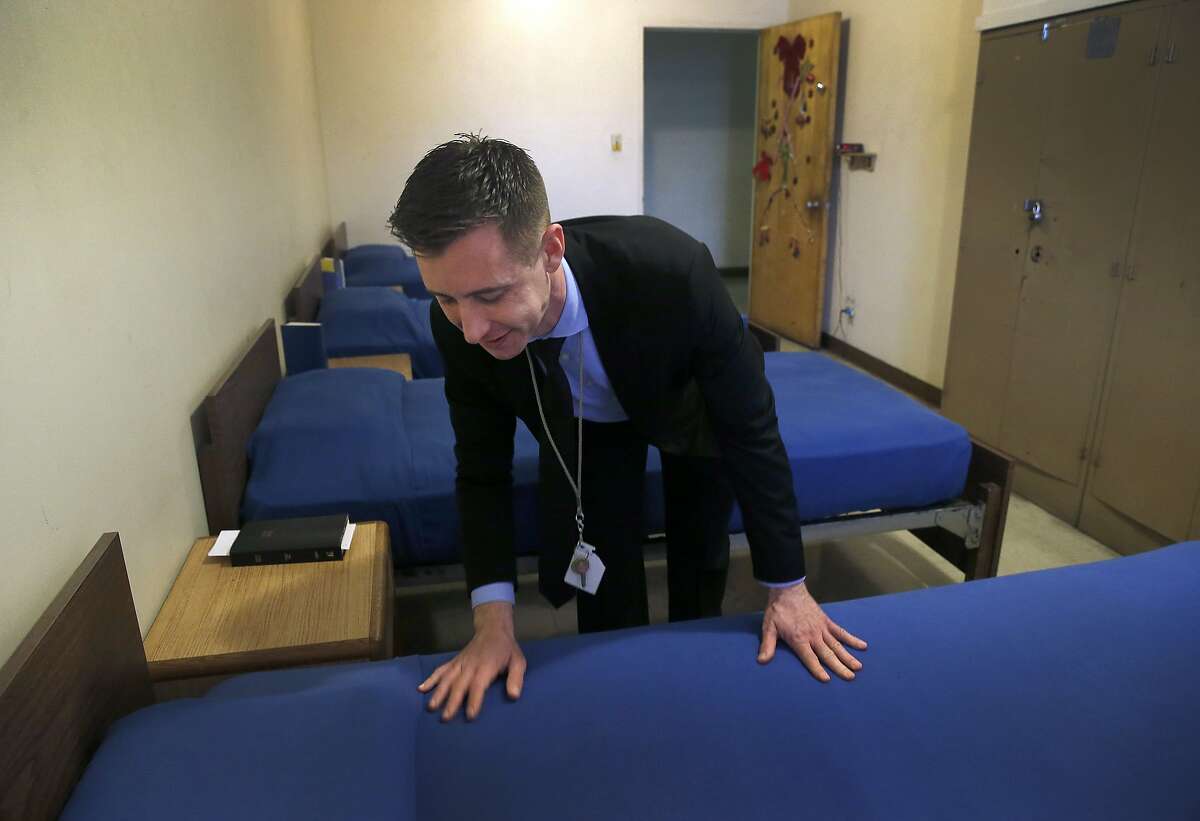 Resident Douglas Groves tidies up inside one of the bedrooms at the Salvation Army Adult Rehabilitation Center in Oakland, Calif. on Thursday, Dec. 10, 2015. Some of the residents at the 130-bed facility are concerned about the lack of heat in the building.