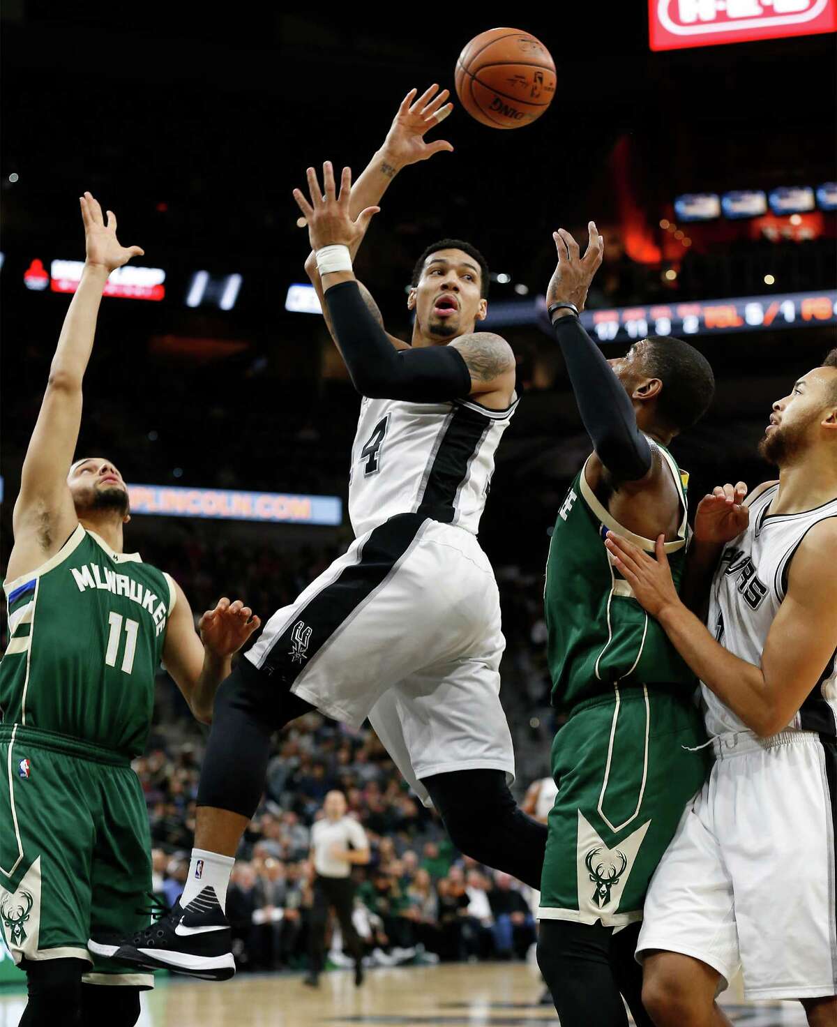 Spurs' Danny Green (14) makes a pass between the Milwaukee Bucks' Tyler Ennis (11) and O.J. Mayo (03) at the AT&T Center on Wednesday, Dec. 2, 2015. (Kin Man Hui/San Antonio Express-News)