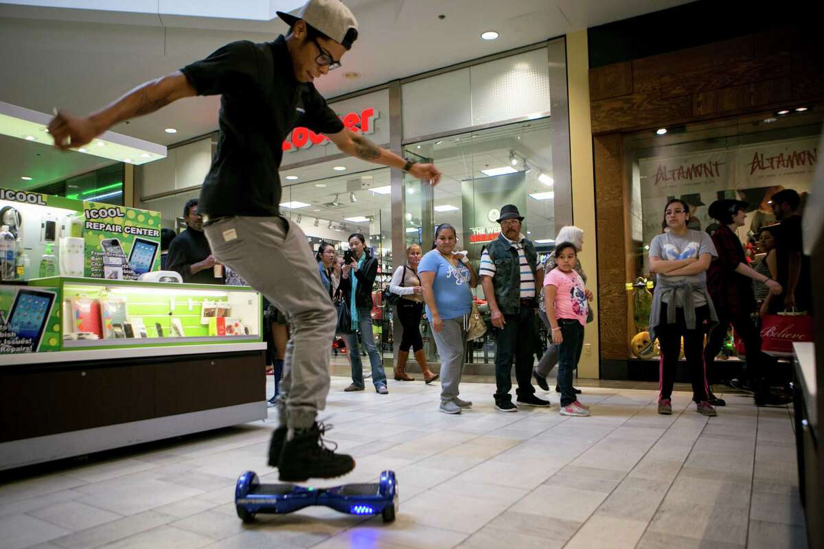 Shannon Clay Jr. performs tricks on a Power Board, a type of hoverboard he sells at a mall kiosk in Austin. Three airlines have decided to ban hoverboards from flights because of the potential fire danger from lithium batteries.