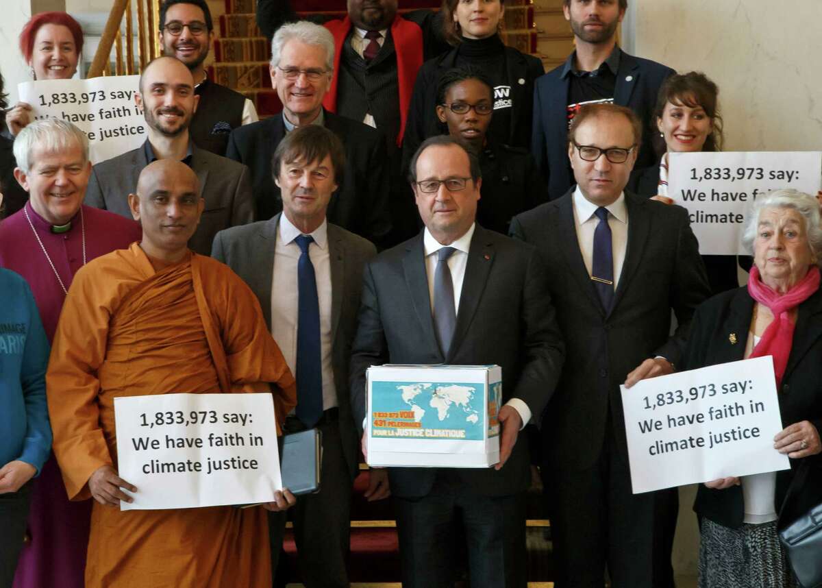 France's President Francois Hollande, center, holds a box containing an international petition to support the climate talks as he poses with religious figures for a group photo at the Elysee Palace in Paris, Thursday, Dec. 10, 2015. France's President Francois Hollande met religious figures lobbying against climate change on the side line of the COP21, United Nations Climate Change Conference in Le Bourget. (AP Photo/Michel Euler, Pool)