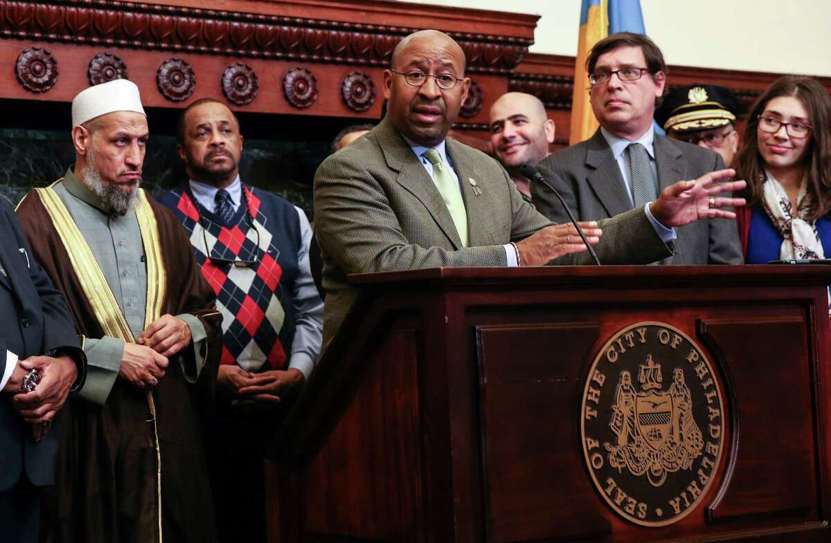 FILE - In this Dec. 8, 2015, file photo, Philadelphia Mayor Michael Nutter, center front, joins with interfaith leaders to speak to the media in Philadelphia, after a severed pig's head was found outside the Al Aqsa Islamic Society. Advocacy groups believe there has been a spike in anti-Muslim incidents across the United States in recent weeks. (Steven M. Falk/The Philadelphia Inquirer via AP, File) PHIX OUT; TV OUT; MAGS OUT; NEWARK OUT; MANDATORY CREDIT ORG XMIT: PAPHQ301