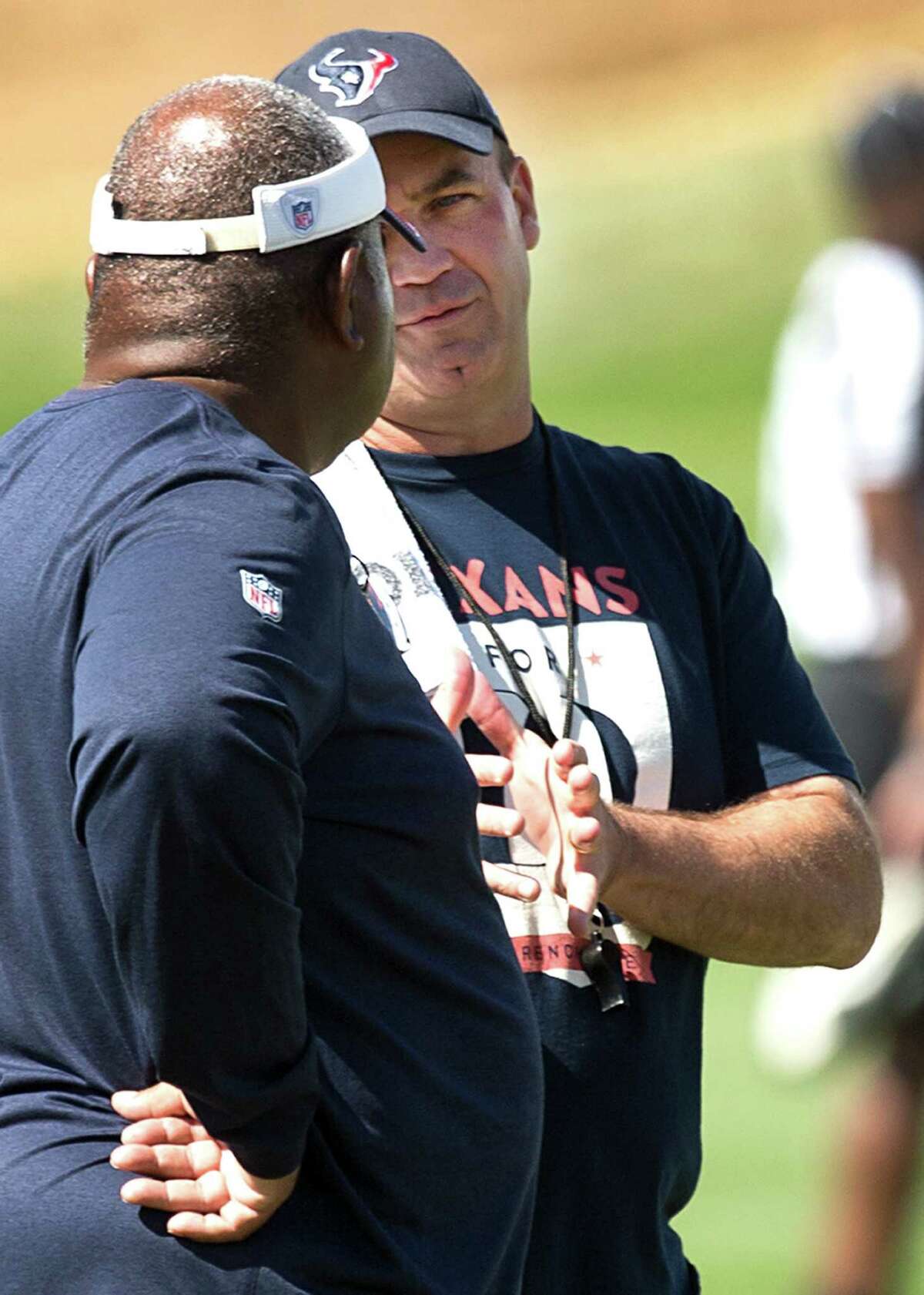 Houston Texans head coach Bill O'Brien, right, talks to defensive coordinator Romero Crennel during a joint practice with the Denver Broncos at the Broncos training facility on Thursday, Aug. 21, 2014, in Englewood, Colo. ( Brett Coomer / Houston Chronicle )