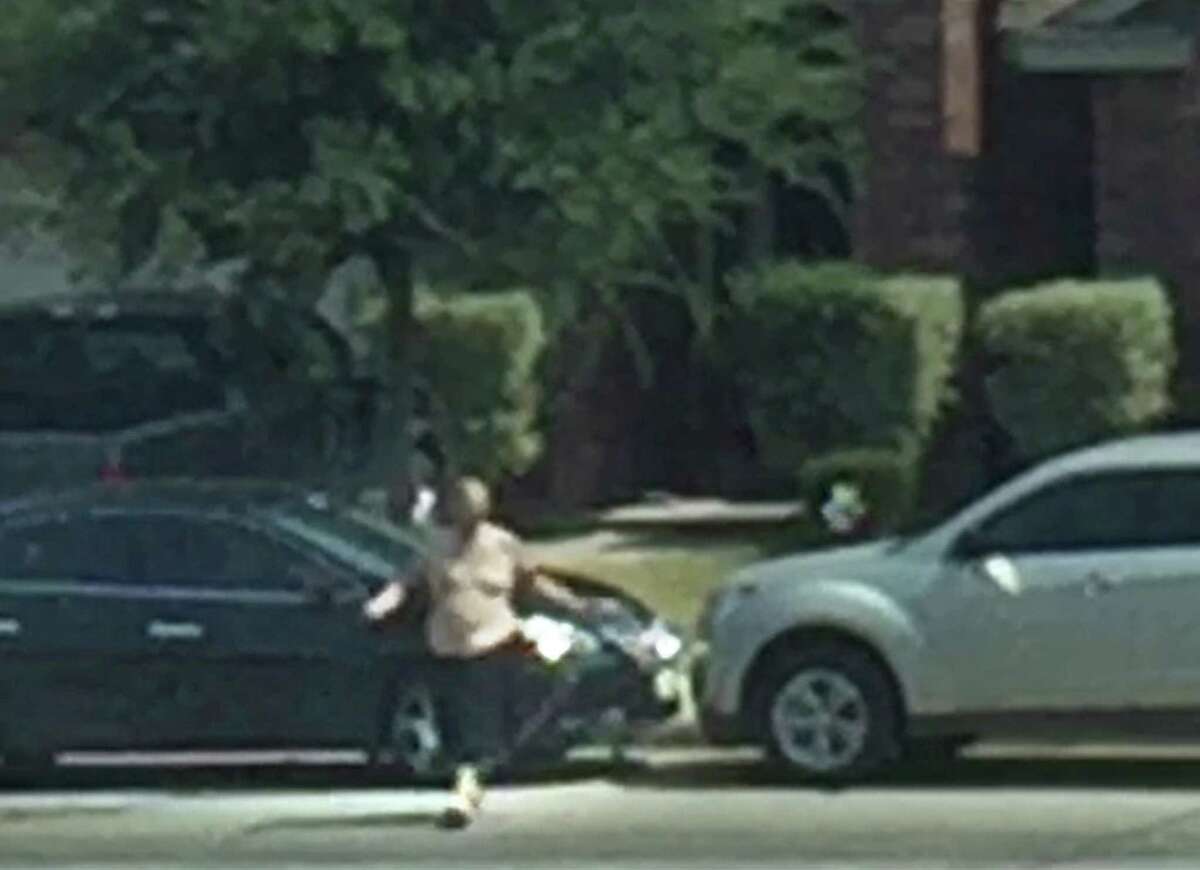 A video frame grab shows Gilbert Flores carrying a taser, used on him by a Bexar County Deputy, as he crosses the street and throws it. The Taser's chord can be seen running from his left arm towards the ground. The video was shot by a neighbor and was released by the sheriff's department on Friday, 12/11/15.