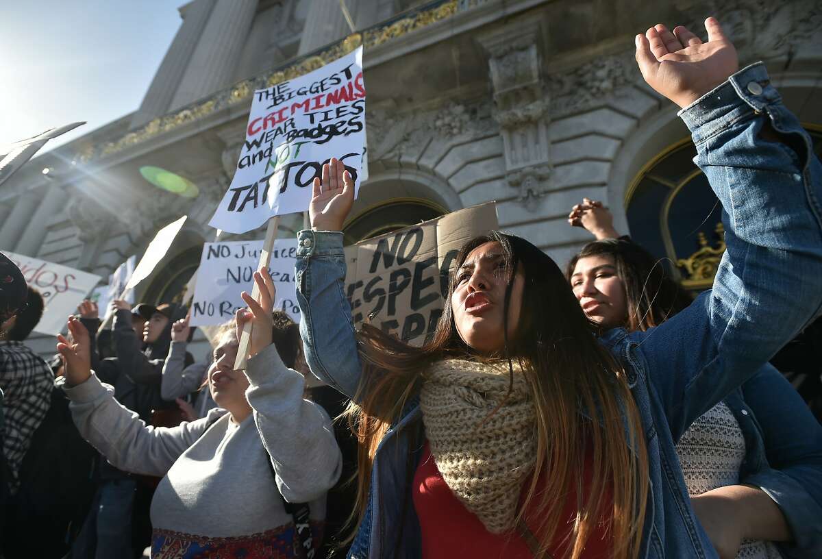 A protester who declined to give her name chants along with others during a police brutality protest at City Hall in San Francisco on Friday, December 11, 2015.