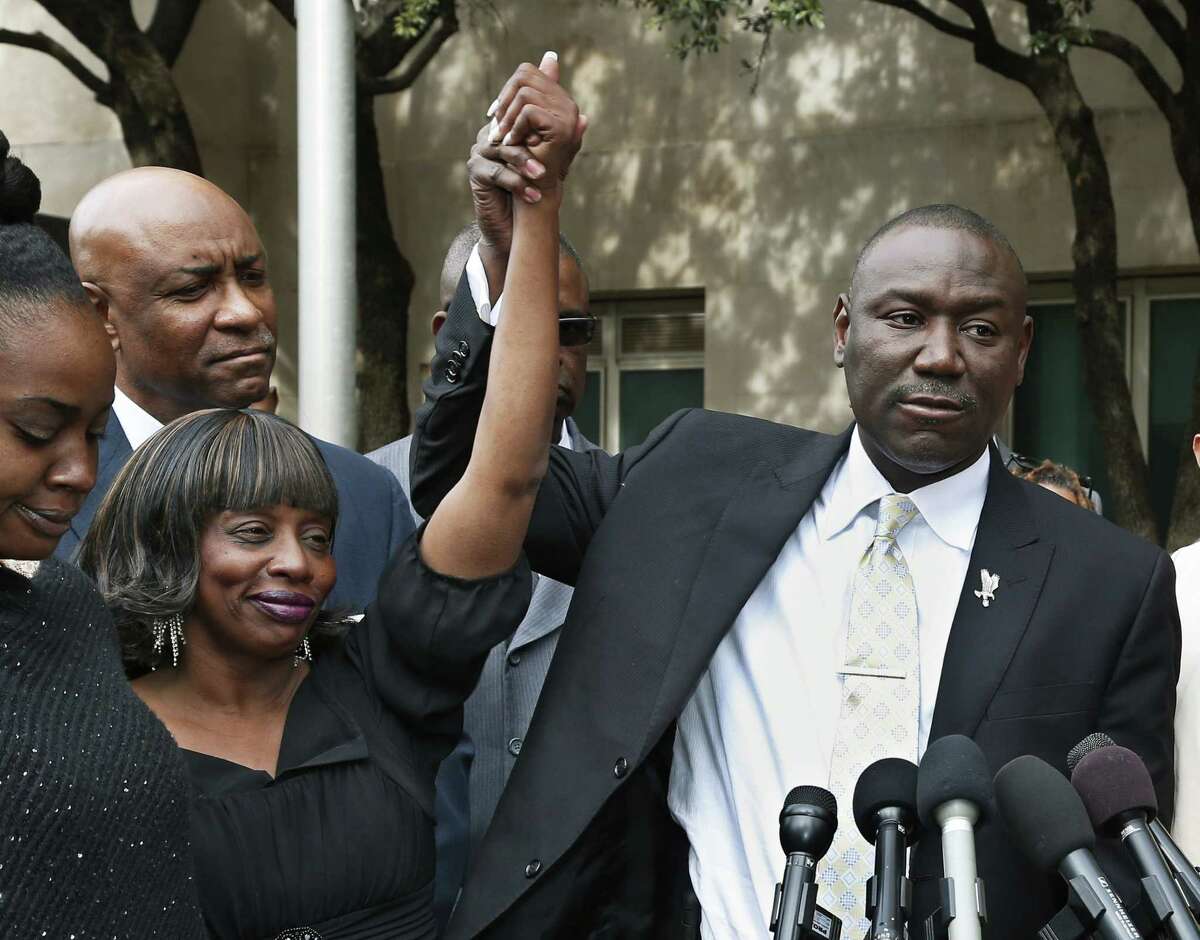 Jannie Ligons, left, one of the victims of sexual assault by former Oklahoma City police officer Daniel Holtzclaw, smiles as attorney Benjamin Crump holds up her arm during a news conference in Oklahoma City, Friday, Dec. 11, 2015. Ligons, whose report launched the police investigation into Holtzclaw, said he picked the wrong lady to stop that night. (AP Photo/Sue Ogrocki)
