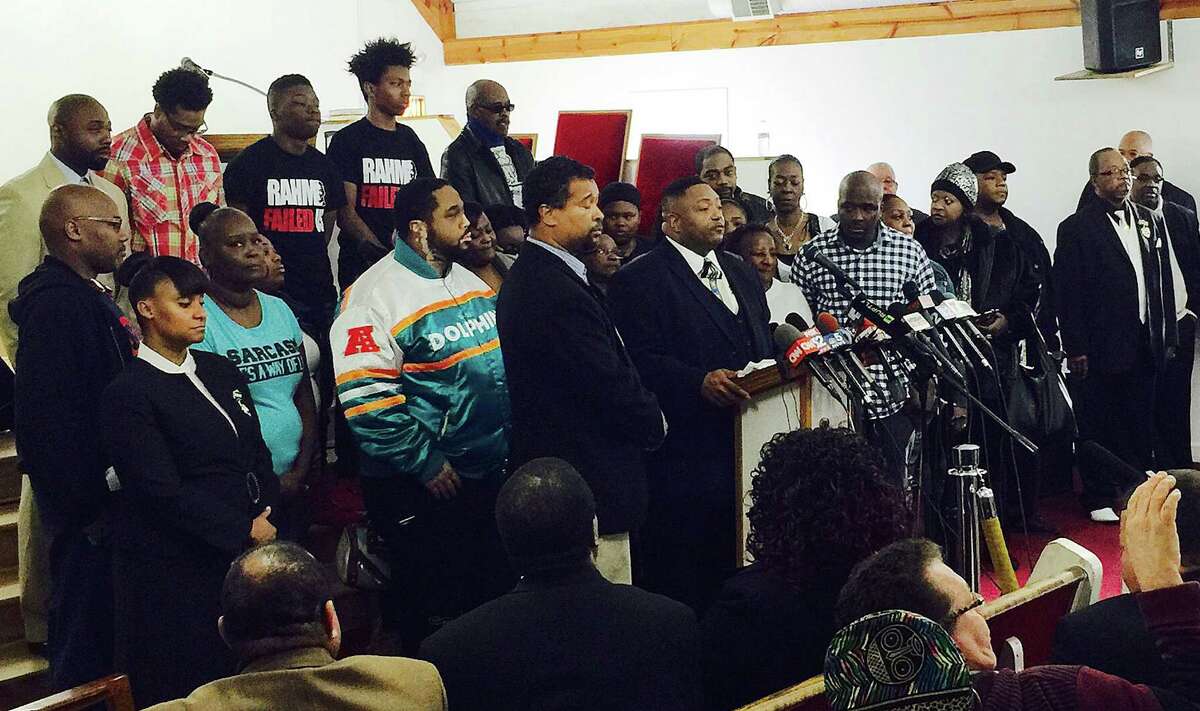 The Rev. Marvin Hunter, center, the great uncle of Laquan McDonald, accompanied by other family members and supporters, speaks at a news conference Friday, Dec. 11, 2015, in Chicago. The family of McDonald, a black teenager shot 16 times by a white Chicago police officer, stepped forward Friday, weeks after a video of the 2014 killing set off days of protests, calls for the mayor's resignation and demands for an overhaul of the police department. (AP Photo/Teresa Crawford)