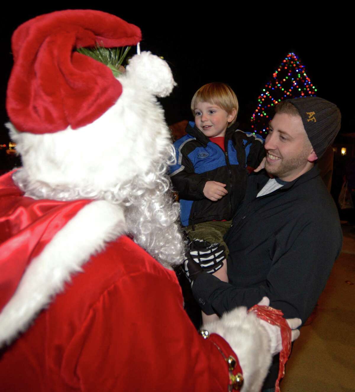 Santa is greeted by Eljah Fille, 2, of Torrington, and his dad Robert after he arrived in a horse-drawn hay wagon for Washington's "Holiday in the Depot", on Friday night, December 11, 2015, in Washington, Conn.