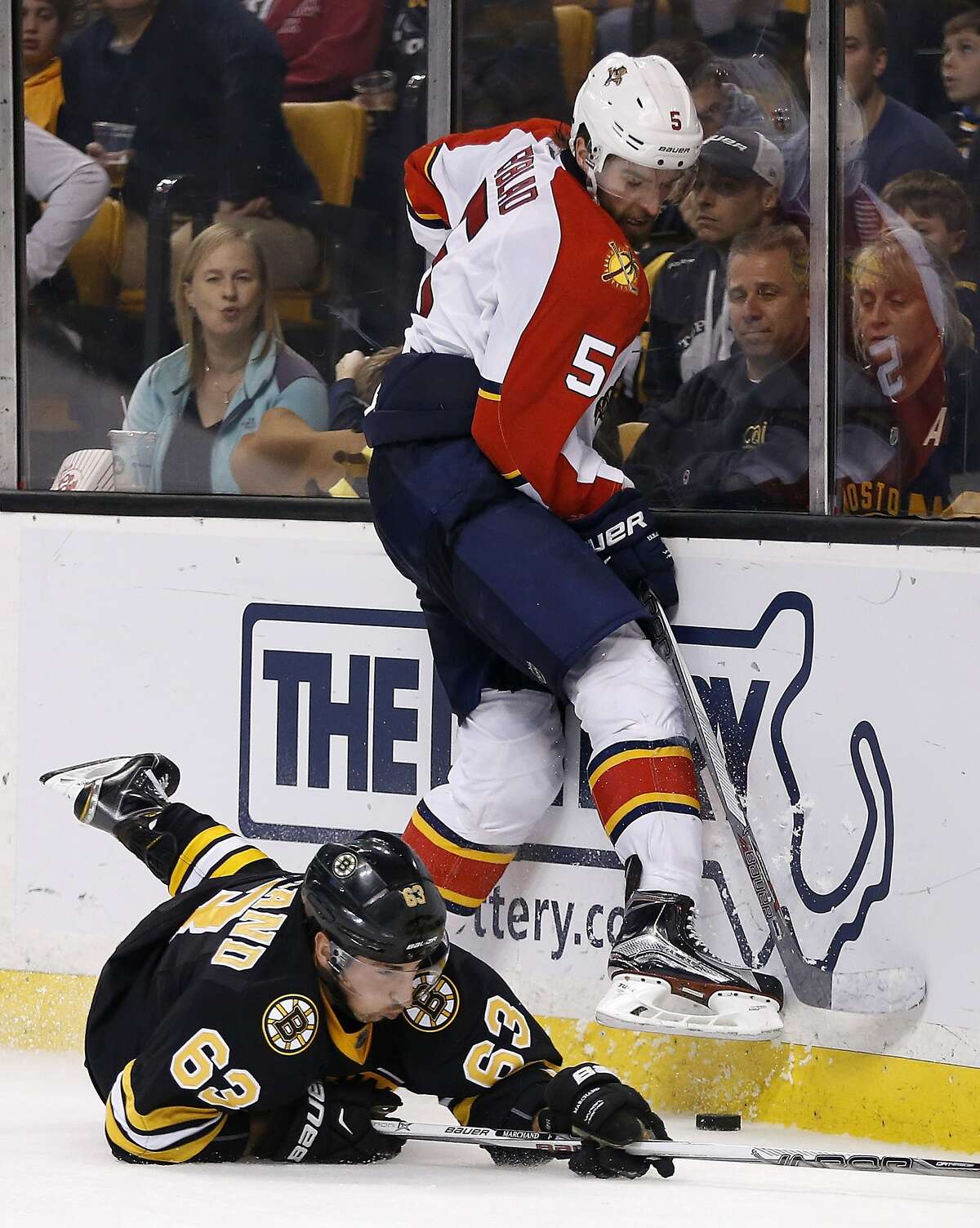 Florida Panthers' Aaron Ekblad (5) and Boston Bruins' Brad Marchand (63) battle for the puck during the second period of an NHL hockey game in Boston, Saturday, Dec. 12, 2015. The Bruins won 3-1. (AP Photo/Michael Dwyer)