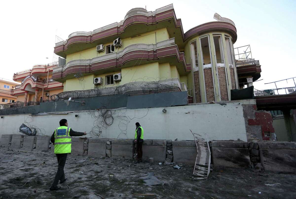 Afghan security personnel inspect the Spanish Embassy in Kabul, Afghanistan, Saturday, Dec. 12, 2015. Explosions and gunfire rocked a diplomatic area of central Kabul overnight as security forces tried to flush out Taliban attackers who claimed responsibility for a deadly car bomb Friday. (AP Photo/Rahmat Gul)