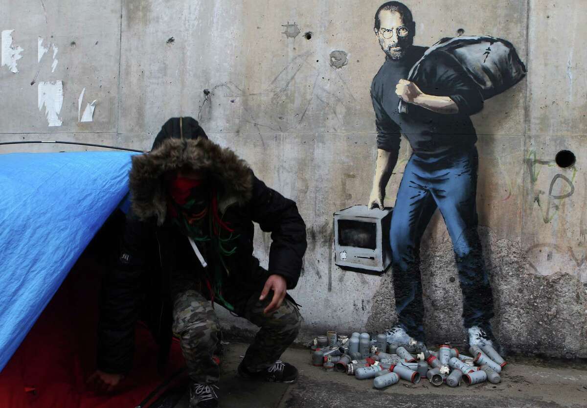 A painting by English graffiti artist Banksy ﻿at the entrance of the Calais refugee camp in France﻿ depicts Steve Jobs, whose father was from Syria.