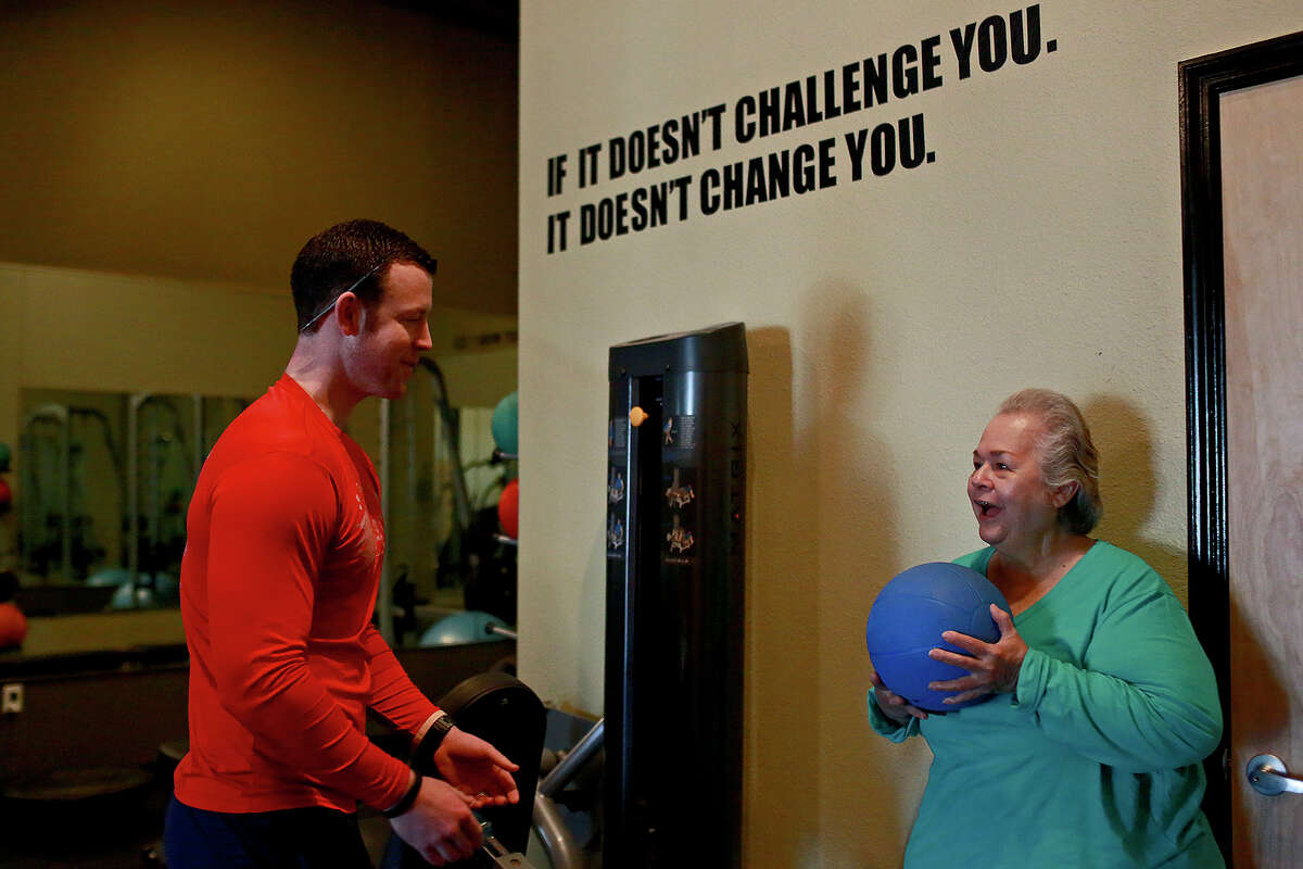 Elena Garcia works out with a weighted ball for the first time with Fit Therapy of Texas co-owner Kenny McClendon at Fit Therapy in Stone Oak on Feb. 19, 2015.