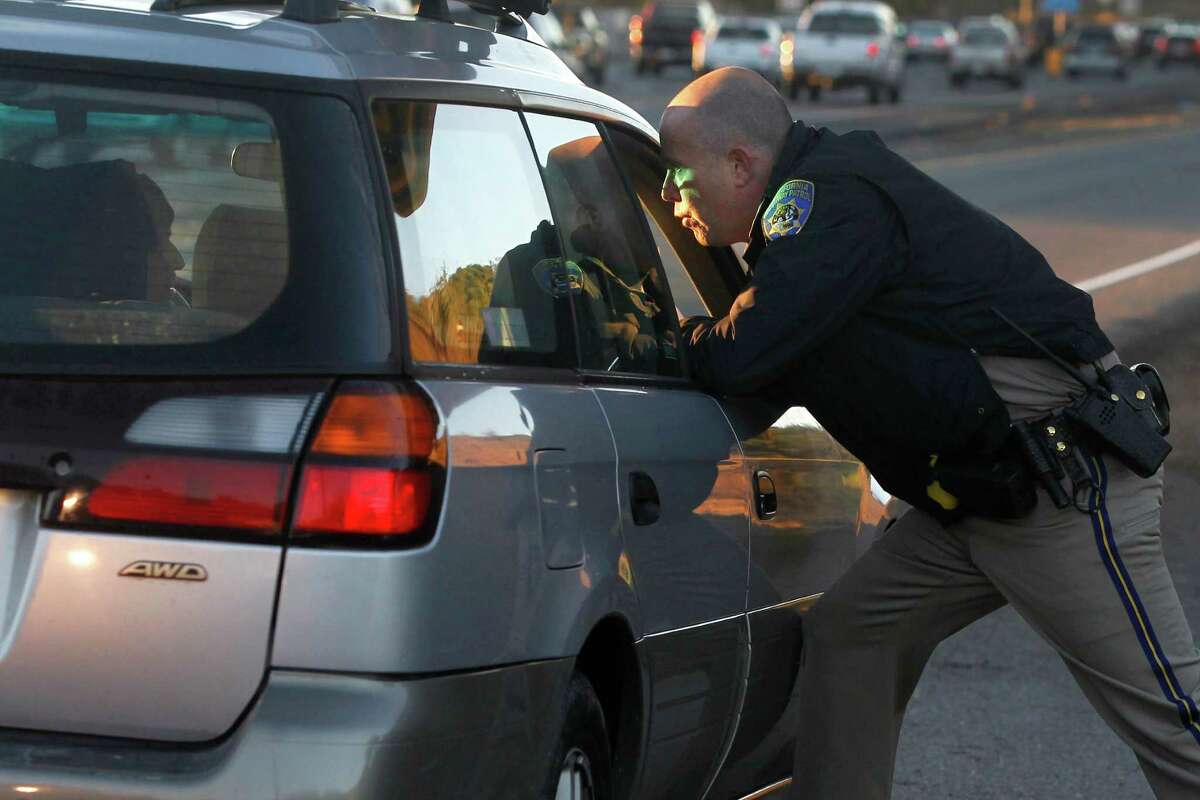 California Highway Patrol Officer Andrew Barclay questions Eddie Servin, who was caught driving solo in a carpool lane, on Highway 101 in San Rafael.