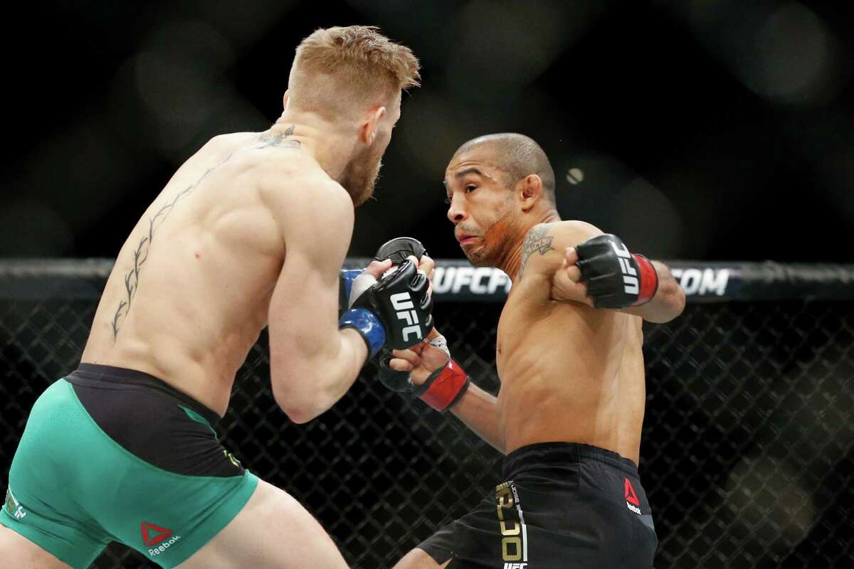 Conor McGregor, left, fights Jose Aldo during a featherweight championship mixed martial arts bout at UFC 194, Saturday, Dec. 12, 2015, in Las Vegas. (AP Photo/John Locher)