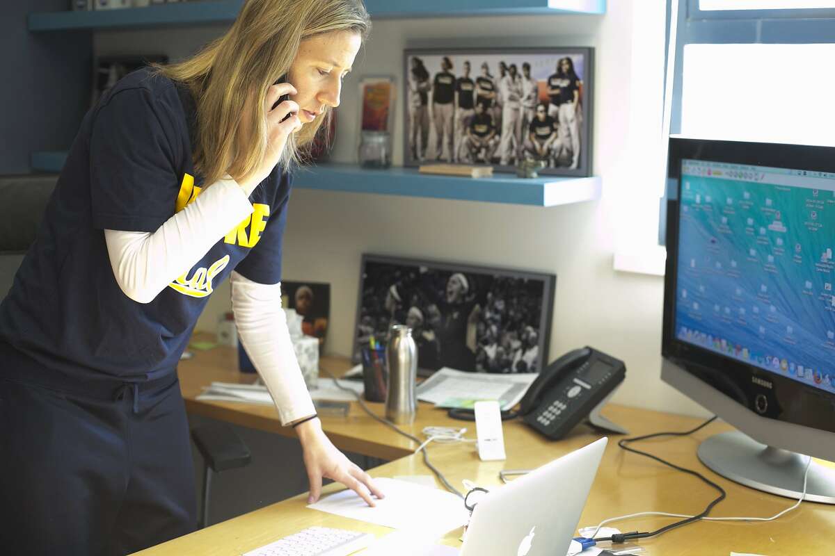 Lindsay Gottlieb, head coach for UC Berkeley Women's basketball, answers a quick phone call shortly after arriving at her office. Coach Gottlieb routinely watches Warriors games for lessons and ideas to integrate into her practices and coaching philosophy. At her office in Berkeley, California on December 14, 2015.