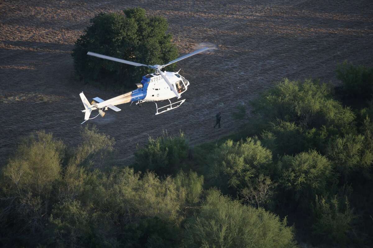 Un helicóptero de Operaciones Marinas y Aéreas de EE.UU trata de hallar a indocumentados en la zona fronteriza entre México y EE.UU el 9 de diciembre de 2015 en un área próxima a Mission, Texas. El número de familias y menores solos inmigrantes ha aumentado en meses recientes.