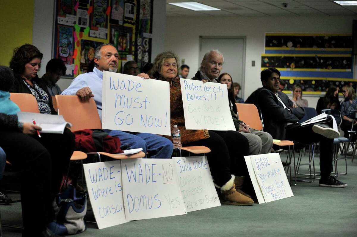 Community members attended an October Board of Education meeting with signs calling for the resignation of board member Julia Wade.