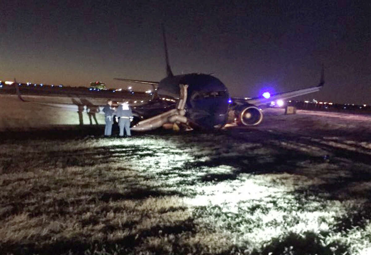 Emergency personnel standby a Southwest Airlines plane that rest on the ground after skidding off the runway at Nashville International Airport, Tuesday, Dec. 15, 2015, in Nashville, Tenn. Officials say three people were injured. (Carson O'Shoney via AP)