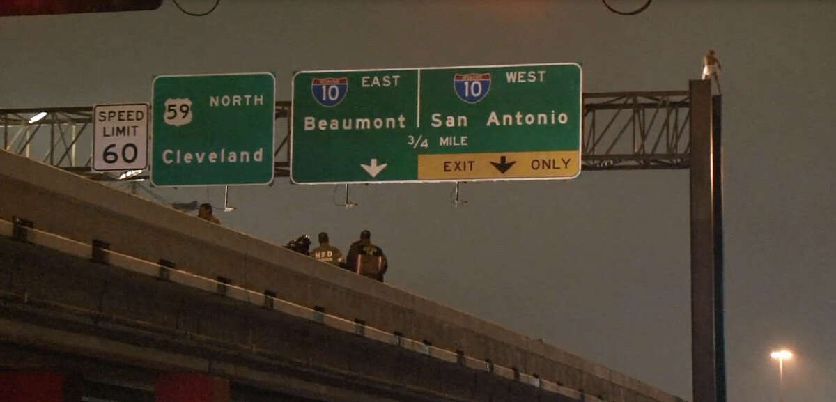 A man wearing nothing but a pair of white underwear scaled a sign over Highway 59 near George R. Brown Convention Center in downtown Houston on Tuesday night, Dec. 15, 2015, holding up traffic in both directions until Houston Police could talk him down.