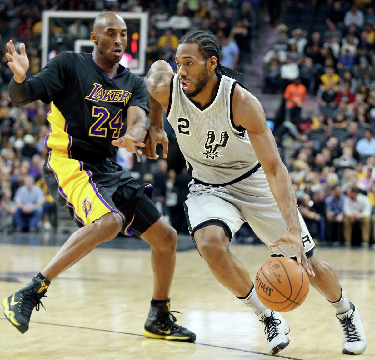 San Antonio Spurs' Kawhi Leonard drives around Los Angeles Lakers' Kobe Bryant during first half action Friday Dec. 11, 2015 at the AT&T Center.