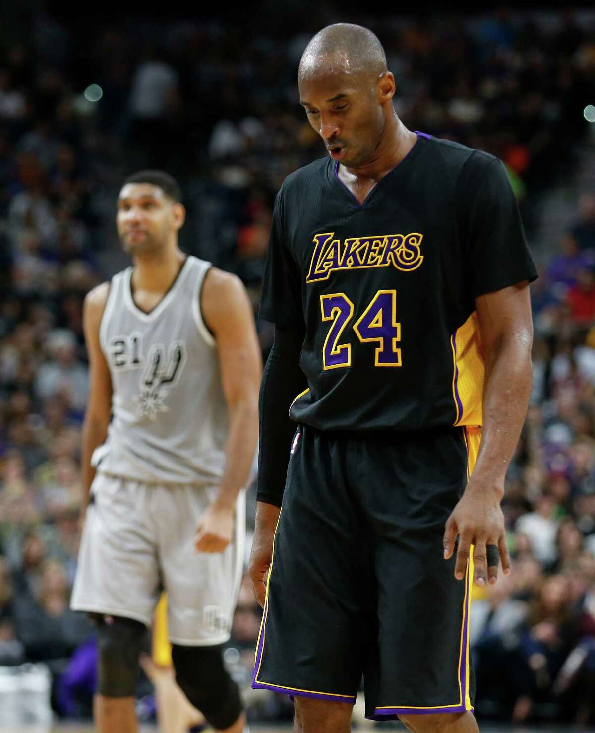 Los Angeles Lakers' Kobe Bryant (24) walks up the floor with Spurs' Tim Duncan (21) at the AT&T Center on Friday, Dec. 11, 2015. (Kin Man Hui/San Antonio Express-News)