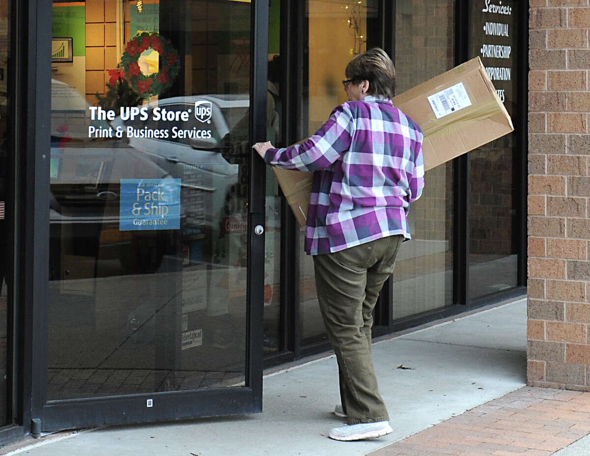 A customer carries a package into The UPS Store on Wednesday, Dec. 16, 2015 in Guilderland, N.Y. (Lori Van Buren / Times Union)