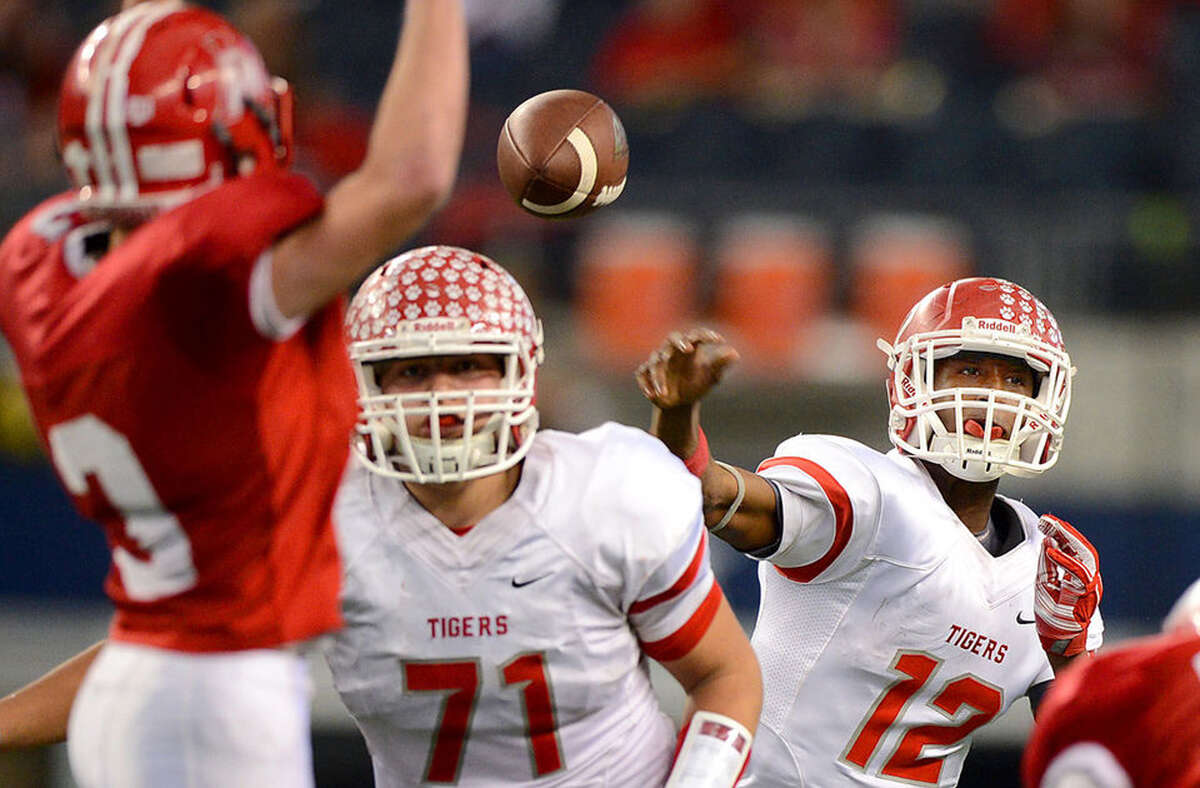 Bremond quarterback Roshauud Paul (right) completes a pass for a first down during the Tigers' 28-21 win over Albany in the Class 2A Division II state championship game Thursday at AT&T Stadium in Arlington. Paul rushed for 149 yards including two touchdowns in the final 5 minutes to cap Bremond's 21-point fourth-quarter rally, giving the school its second state title in football. Photo by Sam Craft/ The Bryan-College Station Eagle