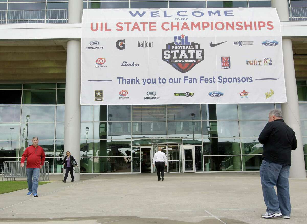 People walk outside of NGR Stadium near a State UIL banner at NRG Park, Wednesday, Dec. 16, 2015, in Houston. The UIL Football State Championship games will be played December 17-19 at NRG Stadium. ( Melissa Phillip / Houston Chronicle )