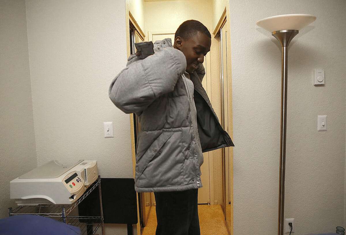 Kelvin Sanders, 20 years old, gets ready to go to his clinic for a check up in Daly City, California, on Friday, December 18, 2015. Behind him is his dialysis machine next to his bed.