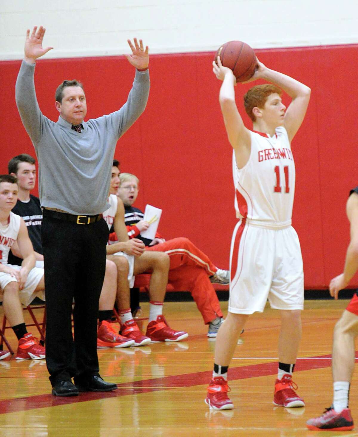 At left, Greenwich High School boys basketball coach Pat Heaton gestures as Greenwich player Henry Golden(#11) looks to pass during the boys basketball game between Greenwich High School and Fairfield Warde High School at Greenwich, Conn., Thursday night, Jan. 22, 2015.