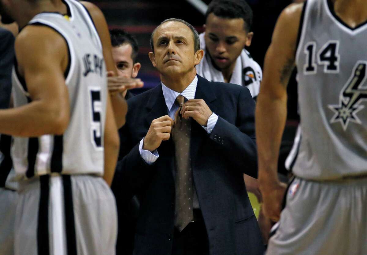 San Antonio Spurs assistant coach Ettore Messina adjusts his tie during a timeout during the first half against the Phoenix Suns on Oct. 16, 2014, in Phoenix.
